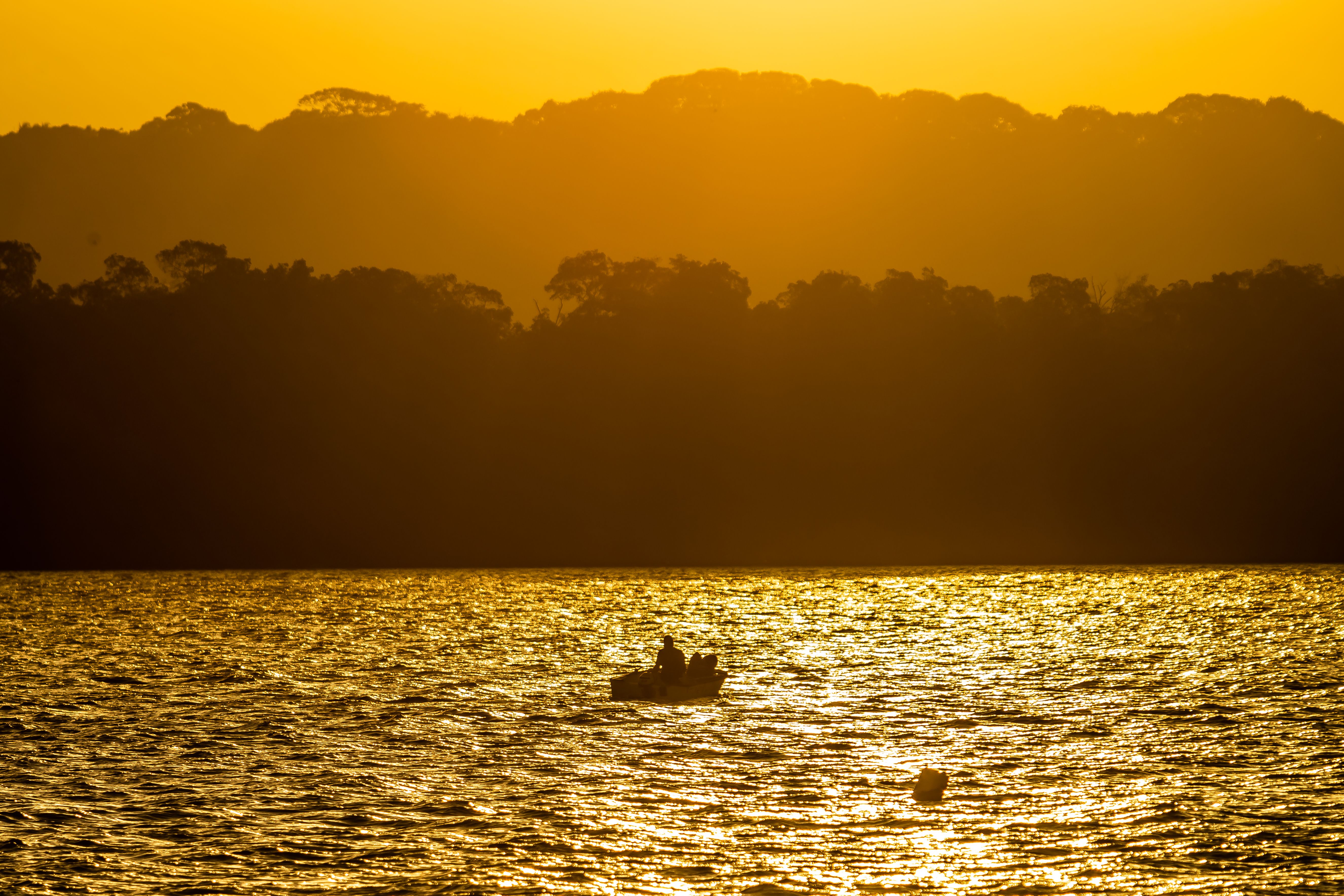 A Silhouette of a Person on a Boat in the Sea · Free Stock Photo