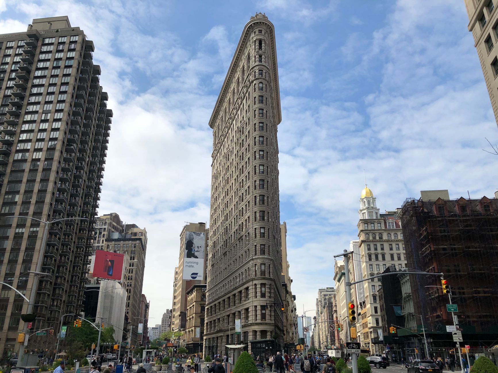 Iconic view of the Flatiron Building surrounded by city life in New York City.