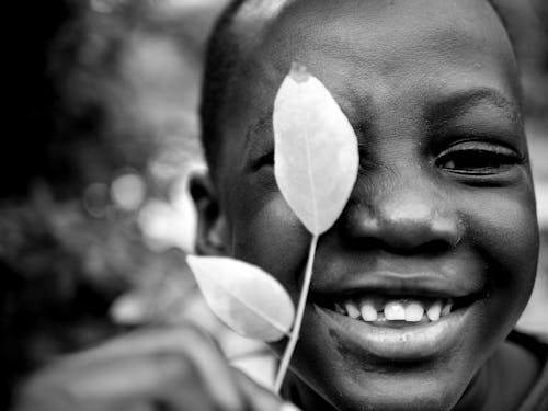 Free Grayscale Photo of a Boy Holding Leaf on His Face Stock Photo