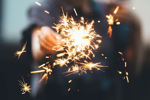 Faceless person holding bright sparkler