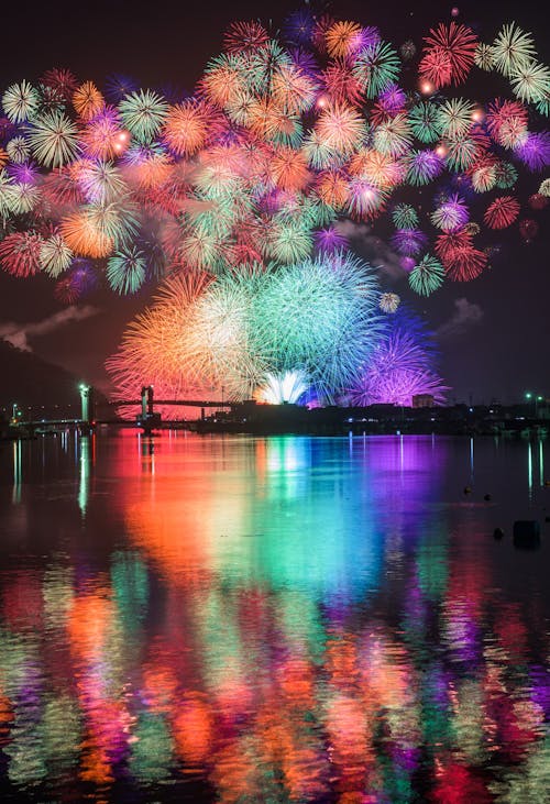 Vibrant fireworks reflecting from surface of lake