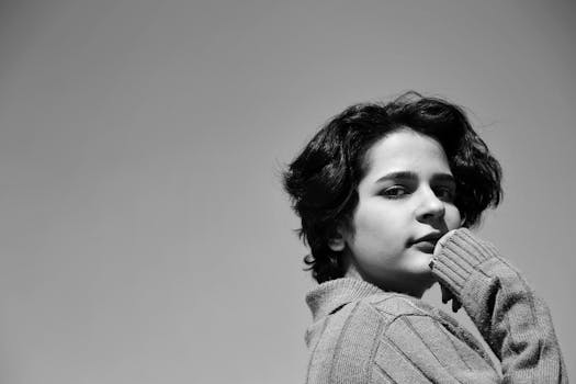 Elegant black and white portrait of a woman in a sweater gazing thoughtfully.