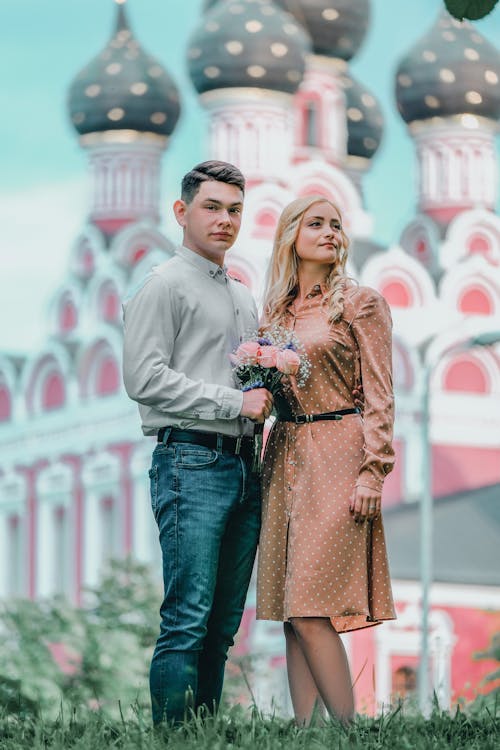 Young couple standing together outside ornamental church