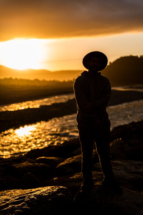 Silhouette of a Man Standing Near the River