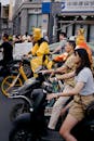 People on Scooters and Bicycles on a City Street in China