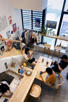 A stylish café in Wuhan, China, showing people engaged with smartphones inside a modern interior.