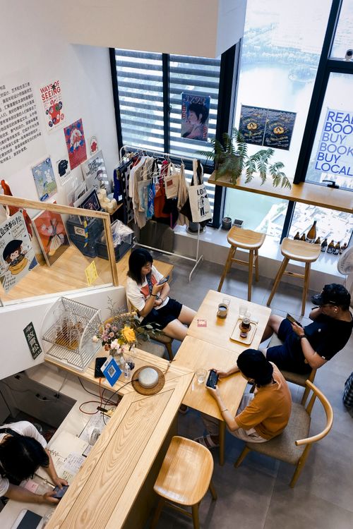 Free A stylish café in Wuhan, China, showing people engaged with smartphones inside a modern interior. Stock Photo