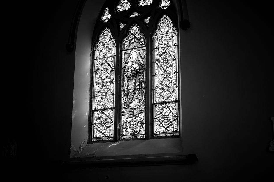 Elegant black and white photo of a religious stained glass window in a cathedral.