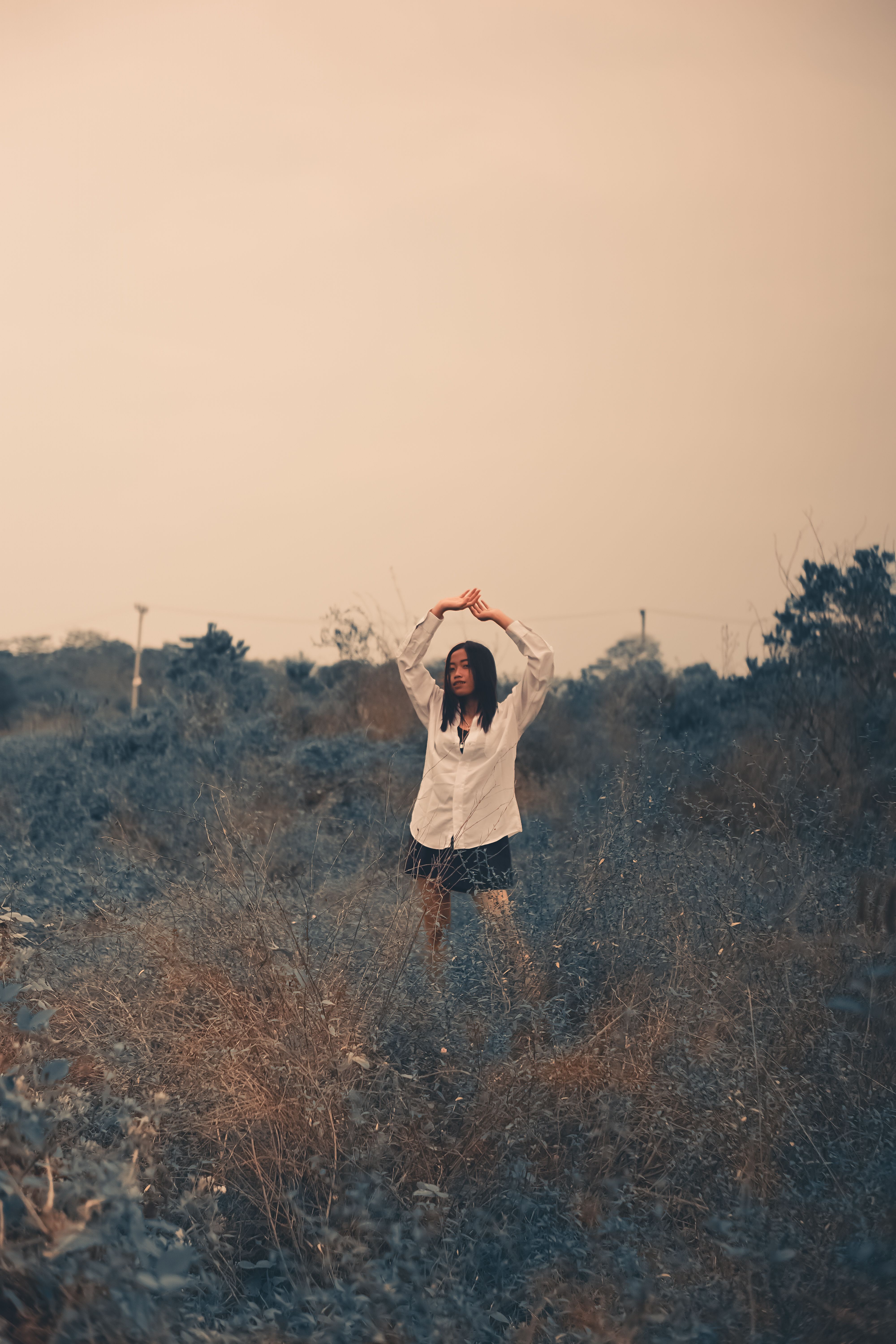 A Woman in White Long Sleeves Shirt Standing on the Grass Field · Free ...