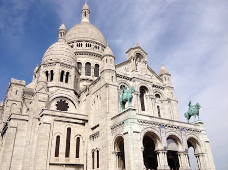 低角度镜头下的巴黎圣心大教堂，展现了其令人惊叹的建筑和晴朗的天空