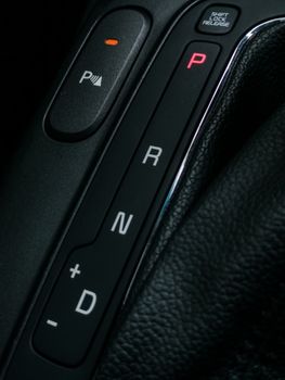Detailed view of a modern car gearshift panel, showcasing design and functionality.