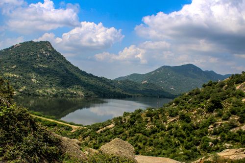 Free Beautiful mountain landscape with a serene lake reflecting the blue sky and clouds, capturing the essence of nature. Stock Photo