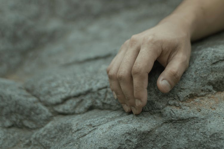 Hand On Rough Rocky Surface