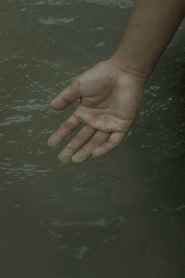 Person Touching Clean Water With Hand