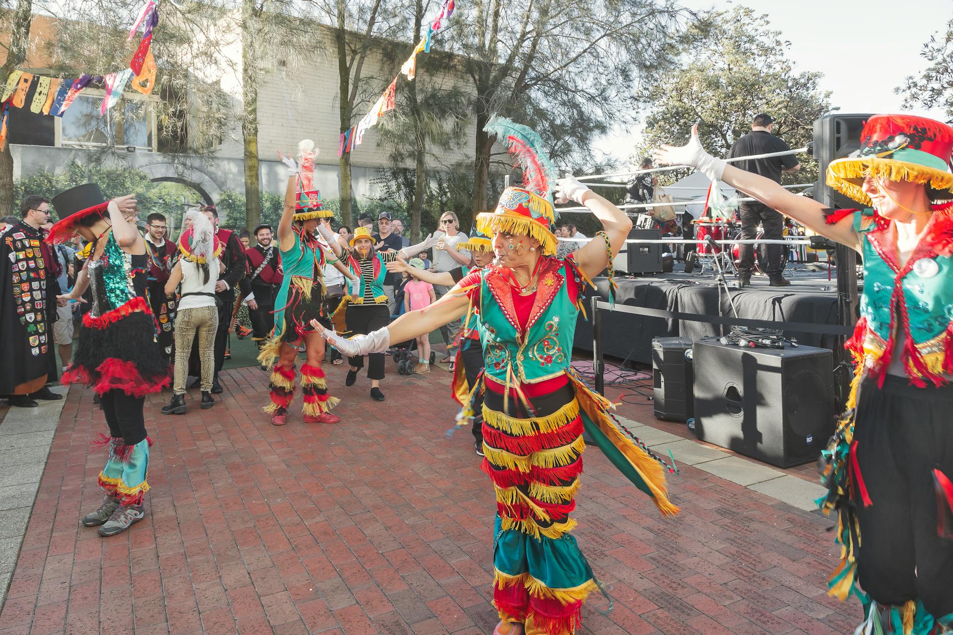 Vibrant street parade with dancers in traditional colorful costumes celebrating outdoors.