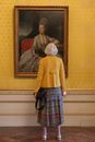 Woman in Yellow Long Sleeve Shirt and Blue and White Plaid Skirt Standing Near Painting