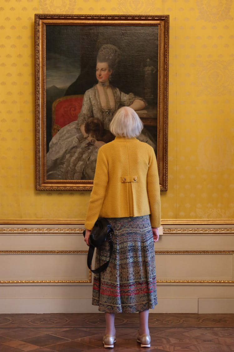 Elderly Woman Looking At A Painting In A Museum 