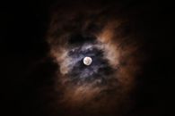 云层照亮了令人惊叹的满月，营造出戏剧性的夜空场景