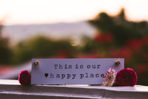 Flowers Lying on the Sides of a Note Saying "This is Our Happy Place"