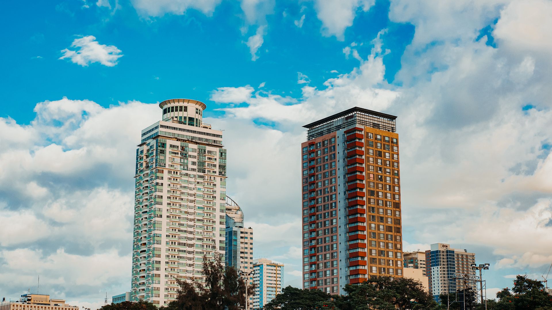 Modern skyscrapers in Manila's skyline against a vibrant sky.
