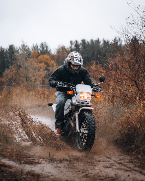 Free Man in Black Jacket Riding a Motorcycle on Dirt Road Stock Photo