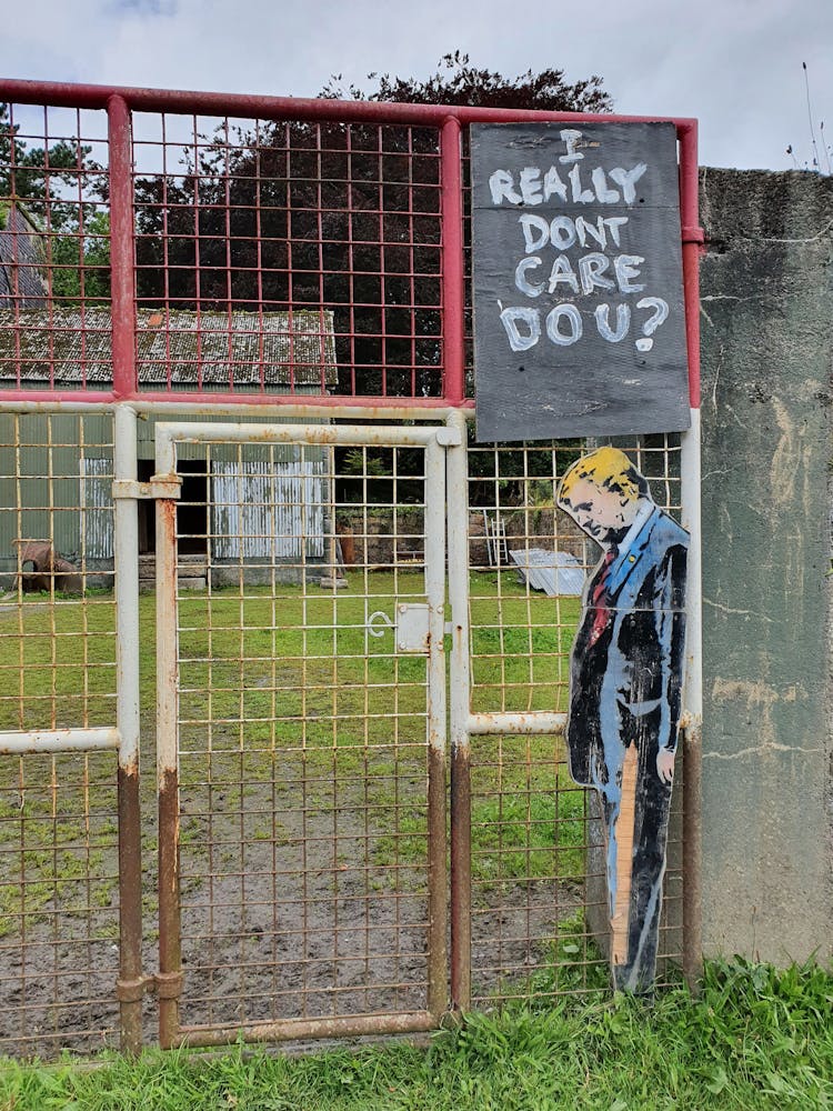 Donald Trump Likeness With A Slogan On An Abandoned Fence 