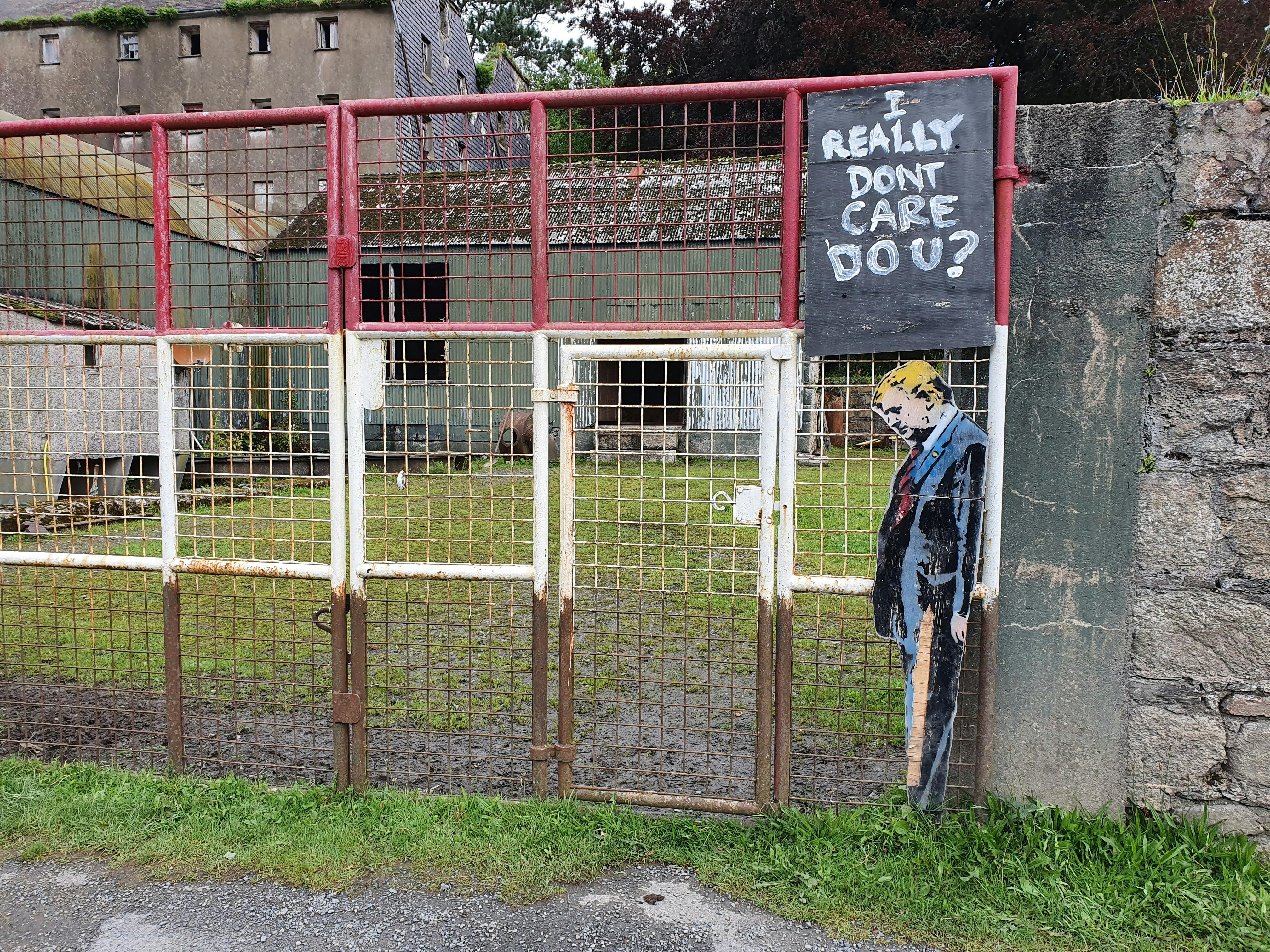 Rustic gate with political graffiti art, capturing a bold message in Ireland.