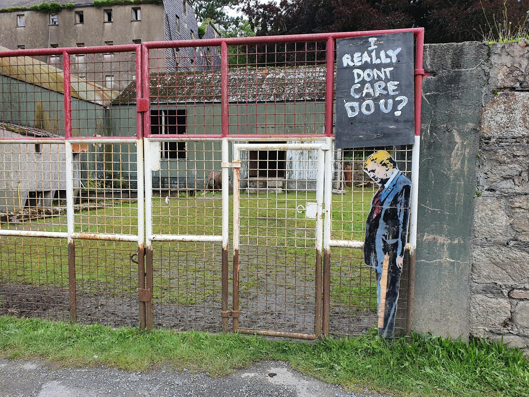 Rustic gate with political graffiti art, capturing a bold message in Ireland.