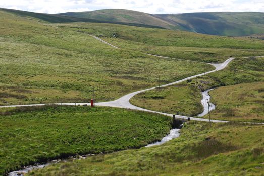 Explore the serene beauty of the Welsh countryside with rolling hills and winding roads.