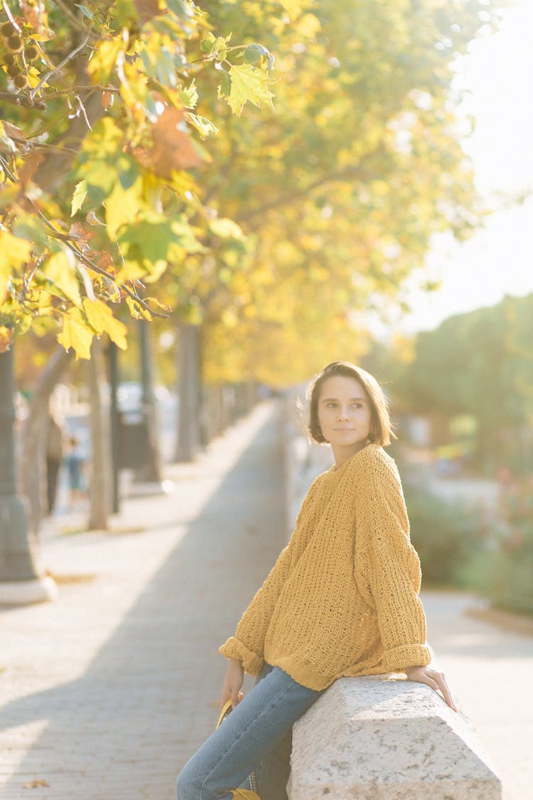 Woman In Knit Sweater Sitting On The Concrete