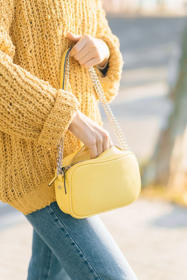 A wide-bodied bag carried on a chain strap in daylight — photo by Nataliya Vaitkevich on Pexels