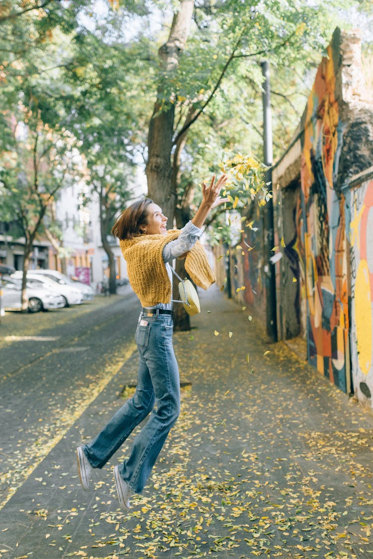 Jump Shot Of A Woman Throwing Leaves 