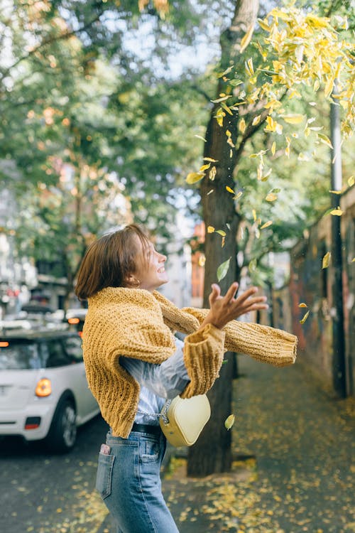 Free A Woman Catching Falling Leaves Stock Photo