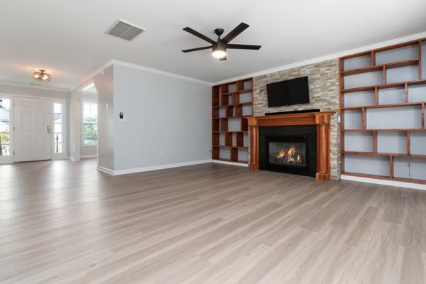 Bright living room with fireplace, built-in shelves and light wood-look floor