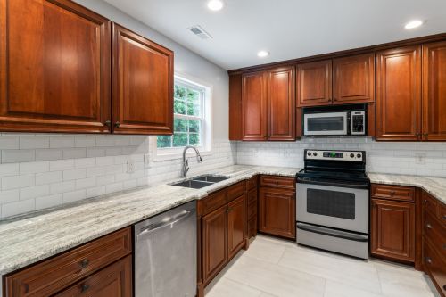 Free Spacious kitchen with wooden cabinets, modern appliances, and granite countertops. Stock Photo