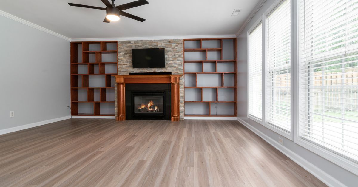 Spacious living room featuring a fireplace, built-in shelving, and large windows.