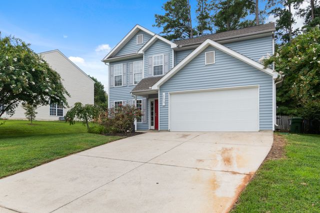 A two-storey clapboard house with a wide driveway. Photo by Curtis Adams on Pexels.