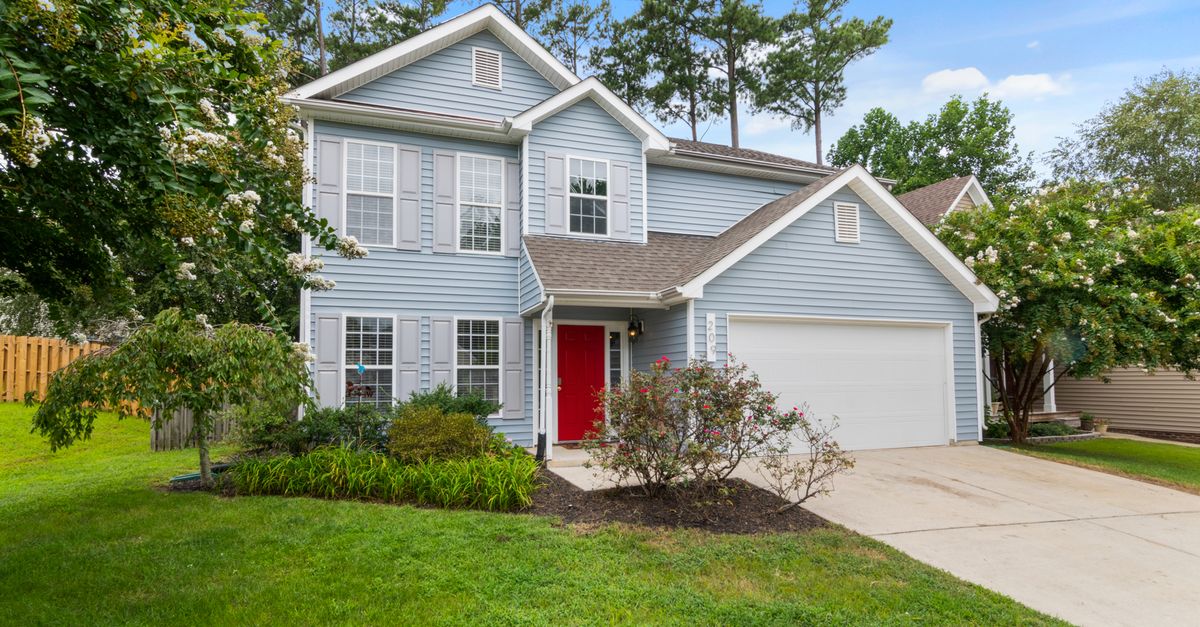 Charming suburban two-story house with a well-maintained lawn and vibrant garden.