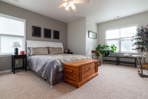 Free Spacious bedroom interior with wooden furniture and soft lighting, perfect for relaxation. Stock Photo