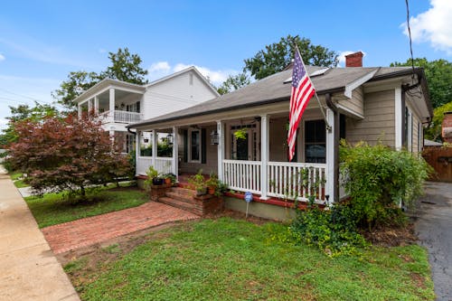 American Bungalow House with a Flag Attached to a Porch 