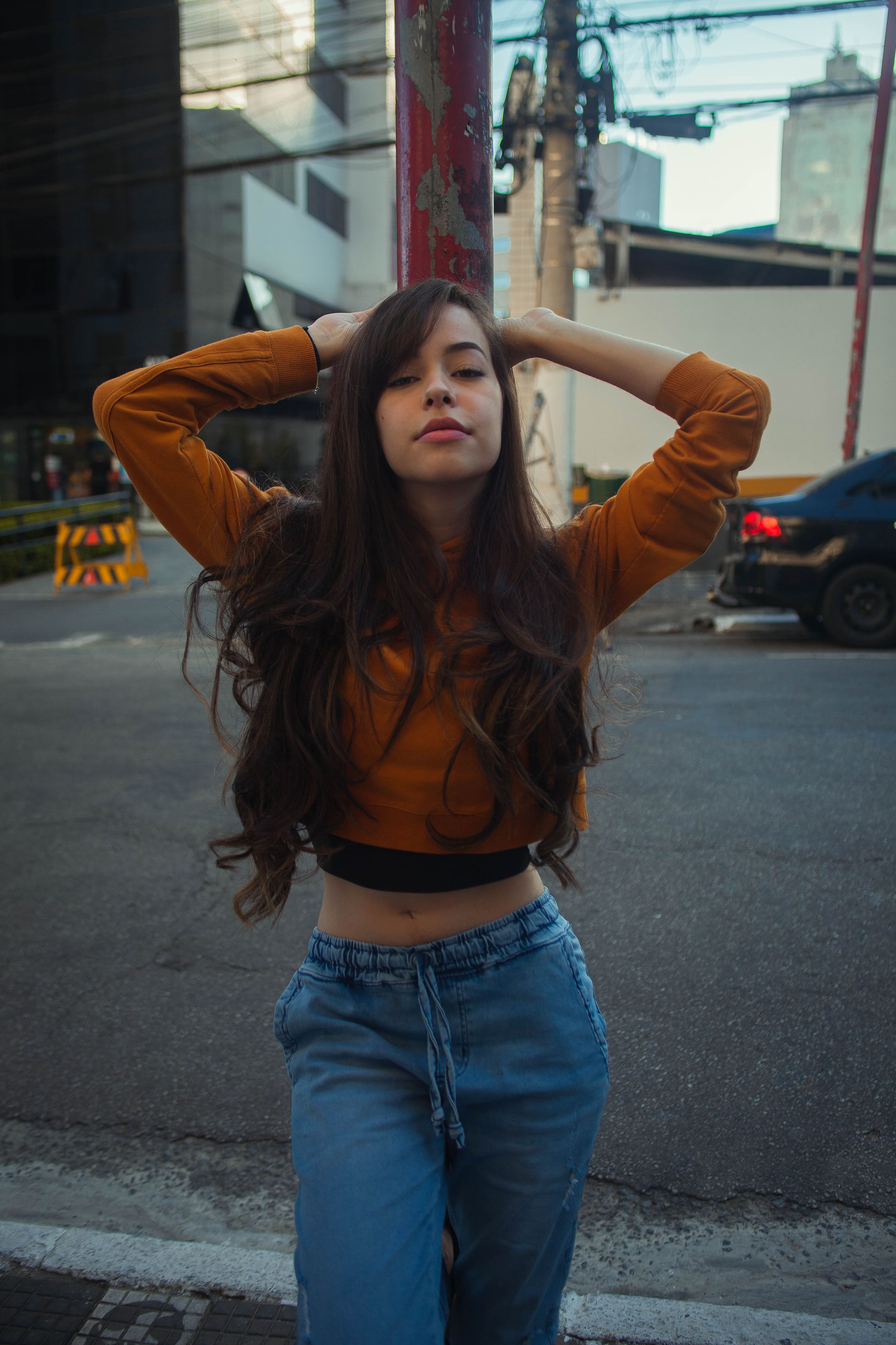 Adolescente estilosa posando com confiança em uma rua da cidade, incorporando a moda urbana.