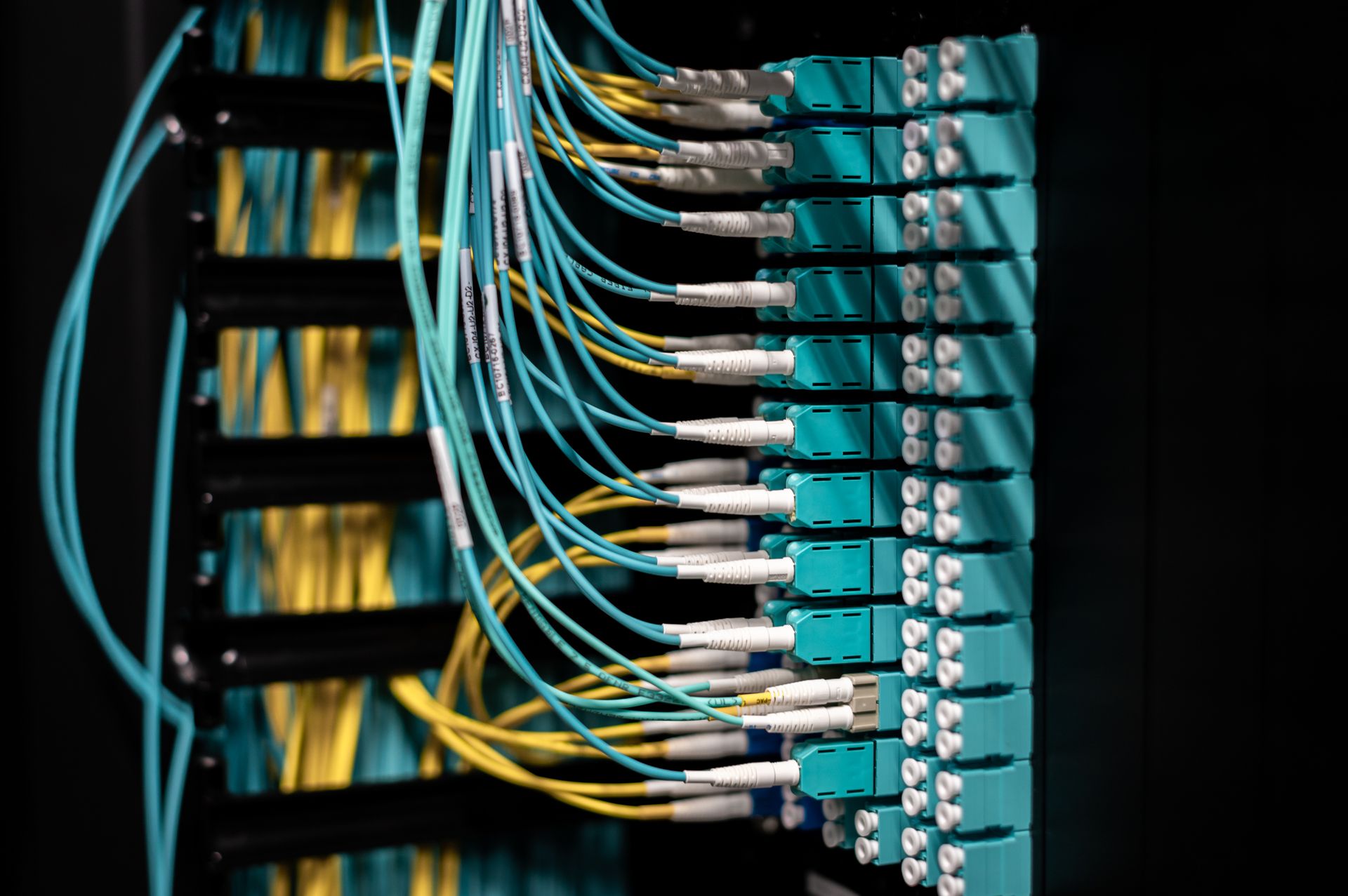 A dimly lit server room with network cabling, representing a cyberattack