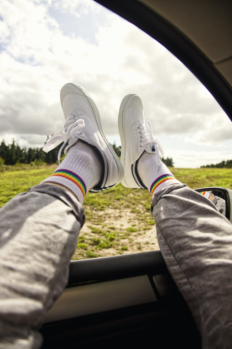 Man Holding His Legs Out Of A Car Window 