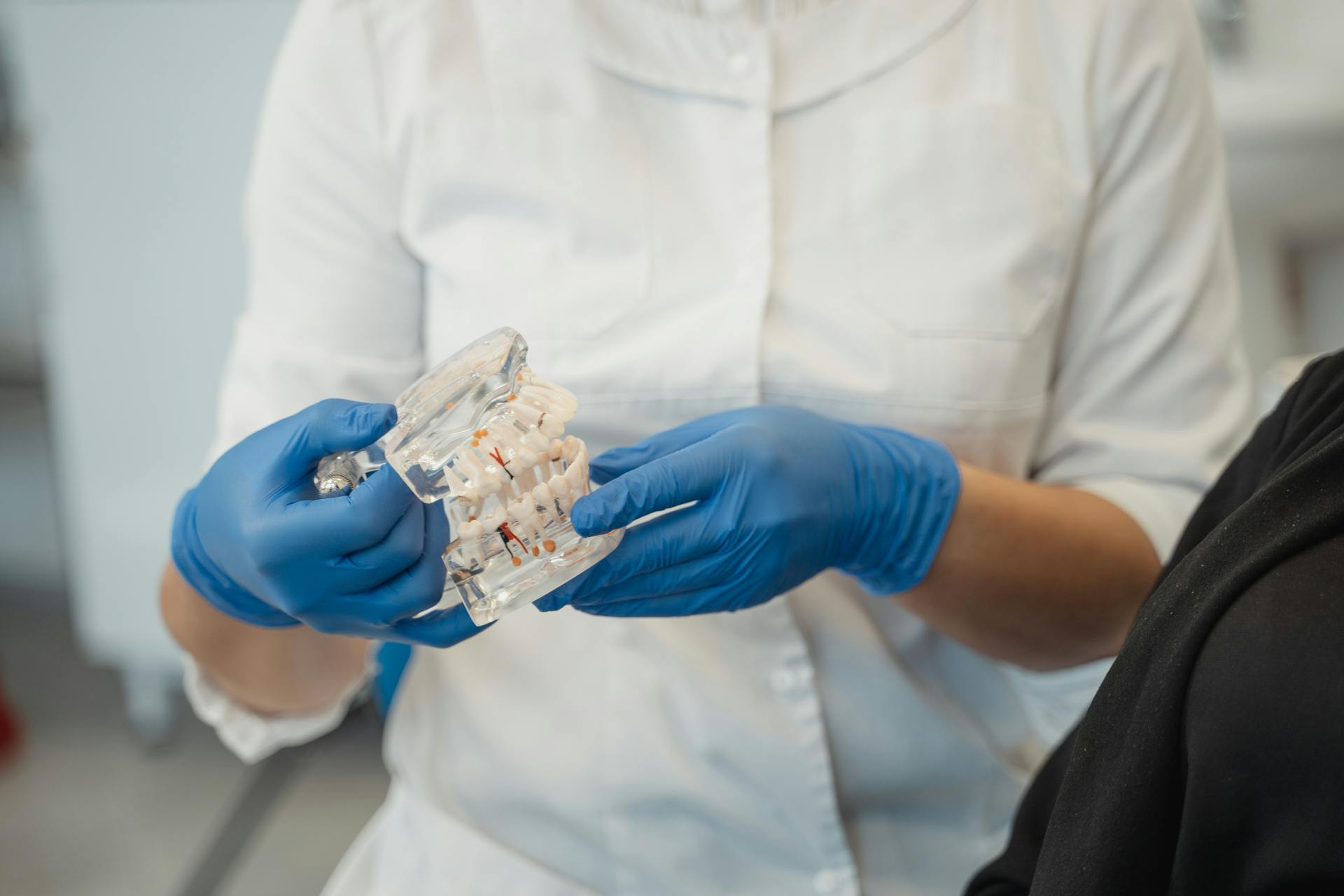 A woman in White Clothes Holding a Dentures