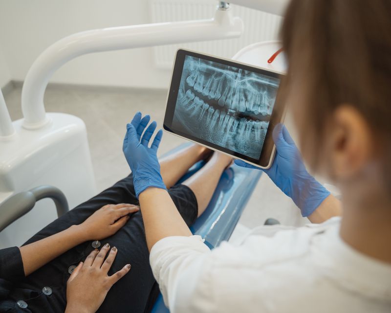 A dentist reviewing a treatment plan and dental scans with a patient