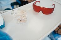 白色牙托上牙科石膏与红色防护眼镜的特写
