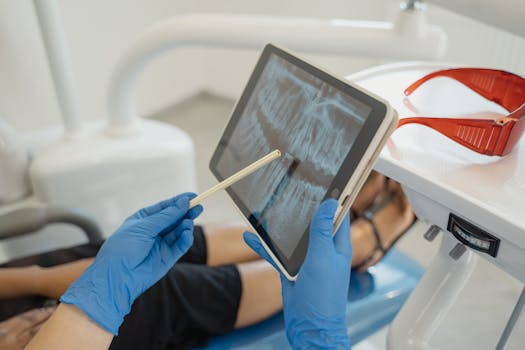 Dentist showing dental x-ray on tablet to patient in a modern clinic setting.