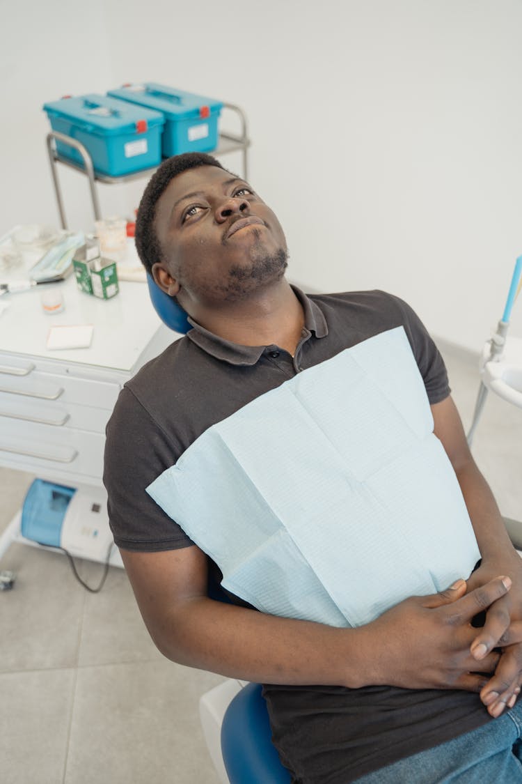 A Man Sitting On A Dental Chair