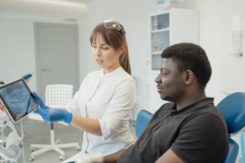 A Dentist Showing a Patient a Dental X-ray Result