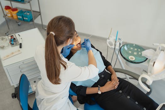 A healthcare professional conducting a dental check-up with patient in clinic.